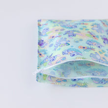 Load image into Gallery viewer, Bumkins Wet Bag: Aloha Stitch lays partially unzipped on a white background.
