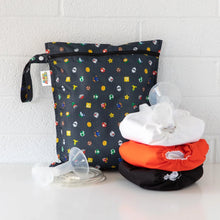 Load image into Gallery viewer, Bumkins Wet Bag: Super Mario™ Lineup sits on a white table against a white brick wall, with cloth diapers and breast pump parts in front.

