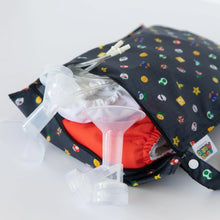 Load image into Gallery viewer, Bumkins Wet Bag: Super Mario™ Lineup holds cloth diapers and breast pump parts on a white background.
