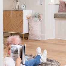 Load image into Gallery viewer, A child reads on a rug with a Bumkins Extra Large Wet Bag: Wander, filled with stuffed animals, at the other end of the room.
