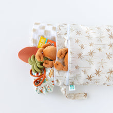 Load image into Gallery viewer, Bumkins Wet/Dry Bag: Palm Daze lays on a white background, filled with plush crabs, a toy, a book, and a soft blanket.
