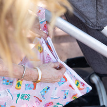 Load image into Gallery viewer, A person unzips a Bumkins Wet/Dry Bag: Boots attached to a stroller handle.
