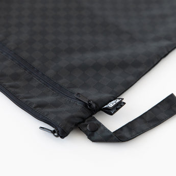 Close-up of Roamio by Bumkins Wet/Dry Bag: Rich Black, featuring zippered compartments and a side handle, on a white background.