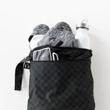 Roamio by Bumkins Wet/Dry Bag: Rich Black holds shoes, clothes, and a water bottle on a white background.