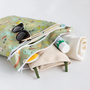 Bumkins Wet/Dry Bag: Camp Gear with sunglasses, a towel, and sunscreen peeking out on a white background.