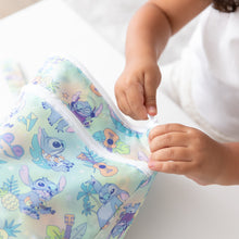 Load image into Gallery viewer, A child opens a vibrant Bumkins Wet/Dry Bag: Aloha Stitch at a white table.
