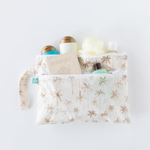 Load image into Gallery viewer, Bumkins Wet/Dry Clutch: Palm Daze holds travel bottles, a passport, and loofah on a white background.
