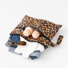 Load image into Gallery viewer, Roamio by Bumkins Wet/Dry Clutch: Leopard lays open on a white background with clothes, sunglasses, and toiletries spilling out.
