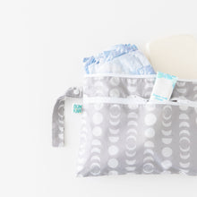 Load image into Gallery viewer, Bumkins Wet/Dry Clutch: Lunar Phase sits on a white background with a diaper, wipes, and rash cream visible.
