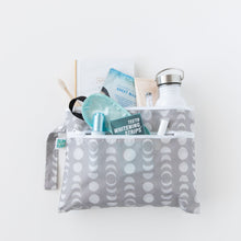 Load image into Gallery viewer, Bumkins Wet/Dry Clutch: Lunar Phase holds a water bottle, sleep mask, notebook, and more on a white background.
