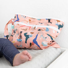 Load image into Gallery viewer, Close-up of a Bumkins Wet/Dry Clutch: Yoga Pals beside a baby's leg on a gray changing pad.

