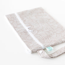 Load image into Gallery viewer, Bumkins Wet/Dry Clutch: Wander, a beige pouch with white patterns and waterproof fabric, sits flat on a white surface.

