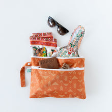 Load image into Gallery viewer, Bumkins Wet/Dry Clutch: Grounded lays on a white background, holding swimwear, passport, sunglasses, and a hair clip.
