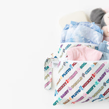 Load image into Gallery viewer, Bumkins Wet/Dry Clutch: Mickey &amp; Friends Varsity, overflowing with clothes and a plush toy, is shown on a white background.
