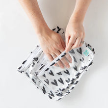 Load image into Gallery viewer, A person uses a cloth to clean the interior of Bumkins Clear Travel Bag 3-Pack: Hearts on a white background.

