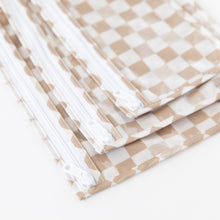 Load image into Gallery viewer, Close-up of Roamio by Bumkins Clear Travel Bag 3 Pack: Sand Check stacked on a white background, with focus on the zipper.
