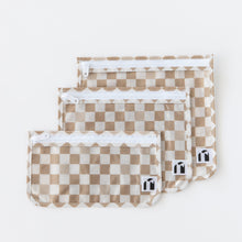 Load image into Gallery viewer, Roamio by Bumkins Clear Travel Bag 3 Pack: Sand Check lays neatly overlapped on a white background.

