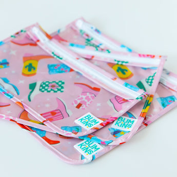 Close-up of Bumkins Clear Travel Bag 3 Pack: Boots stacked on a white background, showcasing the Bumkins logo label.