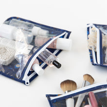 Load image into Gallery viewer, Bumkins Clear Travel Bag 3 Pack: Evil Eye filled with makeup and toiletries are displayed on a white background.
