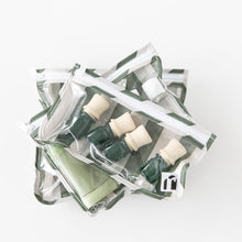 Load image into Gallery viewer, Roamio by Bumkins Clear Travel Bag 3 Pack: Clubhouse Stripe is stacked on a white background, filled with travel-sized bottles.
