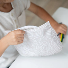 Load image into Gallery viewer, Close-up of a child at a white table placing colorful markers into a Bumkins Clear Travel Bag 3-Pack: Wander.
