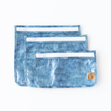 Load image into Gallery viewer, Roamio by Bumkins Clear Travel Bag 3 Pack: Crushed Denim lays overlapped on a white background.
