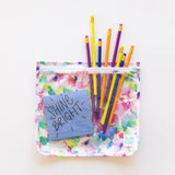 Vibrant pencils peek from a Bumkins Clear Travel Bag 3-Pack: Watercolor on a white background, with a blue note stating “Shine Bright” inside.