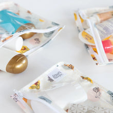Load image into Gallery viewer, Close-up of Bumkins Clear Travel Bag 3-Pack: Winnie and Friends filled with toiletries on a white background.
