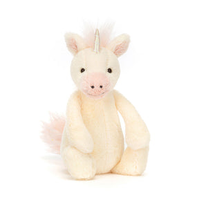 Jellycat Bashful Unicorn Little: a cream plush with pink accents, shiny horn, and fluffy tail sits upright.