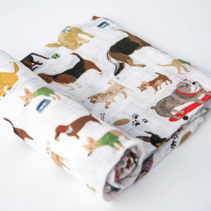 The Cotton Swaddle, Woof by Little Unicorn features colorful dogs—perfect as a baby swaddle blanket on any white surface.
