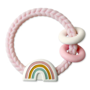 Itzy Ritzy Ritzy Rattle, Rainbow: Pink braided teether with pastel rings, rainbow charm & gentle rattle for soothing comfort.