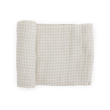 Little Unicorn Cotton Swaddle in Tan Gingham, partially rolled, shown on a white background.