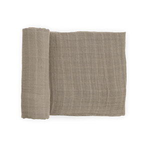 Little Unicorn Organic Cotton Muslin Swaddle Blanket in Driftwood, OEKO-TEX certified, pictured rolled and unrolled on white.