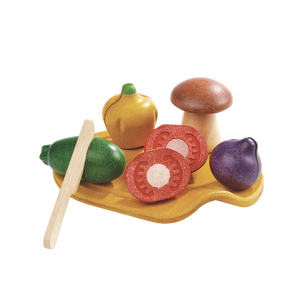 Sliceable PlanToys Assorted Vegetables Set on a board with toy knife, ideal for pretend play with veggies and mushrooms.