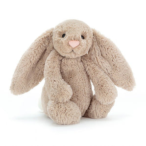 Jellycat Bashful Bunny Beige Medium, a plush toy with floppy ears and a pink nose, sits softly against a white background.
