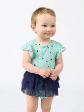 Load image into Gallery viewer, A baby smiles in a Skirt Onesie, Baseball Buddies print by Emerson and Friends, against a white background.
