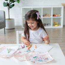 Load image into Gallery viewer, A young girl colors with crayons at a white table while Bumkins Clear Travel Bag 3-Pack: Lace lays nearby.
