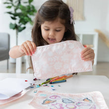 Load image into Gallery viewer, A young girl plays with crayons and stickers at a white table while holding a Bumkins Clear Travel Bag 3-Pack: Lace.
