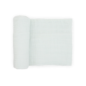 A Cotton Muslin Swaddle Blanket in Pale Pinstripe by Little Unicorn is partially unrolled on a white background.