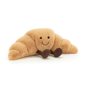 Jellycat Amuseables Croissant plush toy features a smiling face and brown feet, shown on a white background.