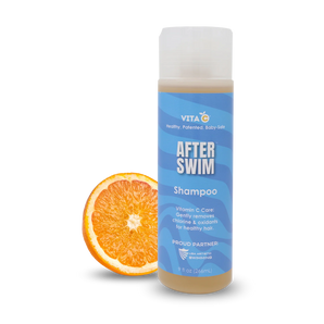 Vita C After Swim Shampoo, a chlorine neutralizer, stands next to a sliced orange on a white background.