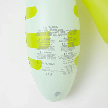 Close-up of safety warnings and batch info on Sunnylifes Monty the Monster, a lime-accented white inflatable pool noodle for kids.