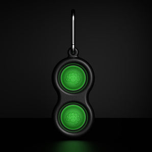 The Simpl Dimpl by Fat Brain Toy Co is a black keychain with glow-in-the-dark green cloud buttons perfect for tactile play.