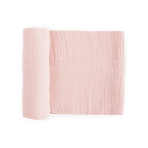 Little Unicorn Cotton Swaddle in light pink, partly rolled up on a white background.