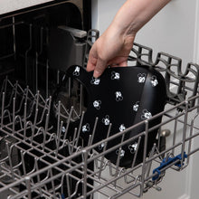 Load image into Gallery viewer, A person places Bumkins Silicone Bib: Mickey Mouse Faces in the top rack of an open dishwasher.
